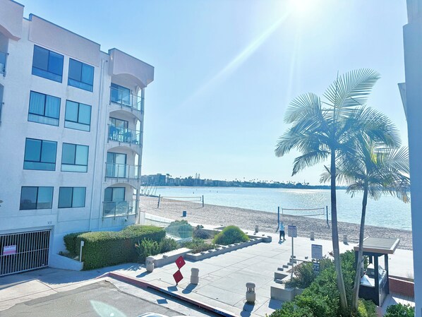 Un edificio moderno con varios balcones que dan a una playa.