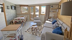 Uma sala de estar moderna com um sofá, uma mesa de jantar e um carrinho de cozinha.