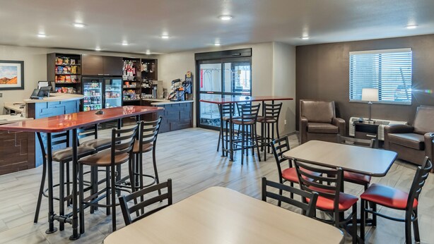 Un restaurant moderne doté d’un bar, d’un espace pour s’asseoir et d’une cuisine située à l’arrière-plan.