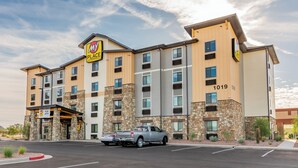 Un hôtel à plusieurs étages, doté d’une façade en pierre, d’une enseigne « My Place » et d’un parking où est garé un camion.