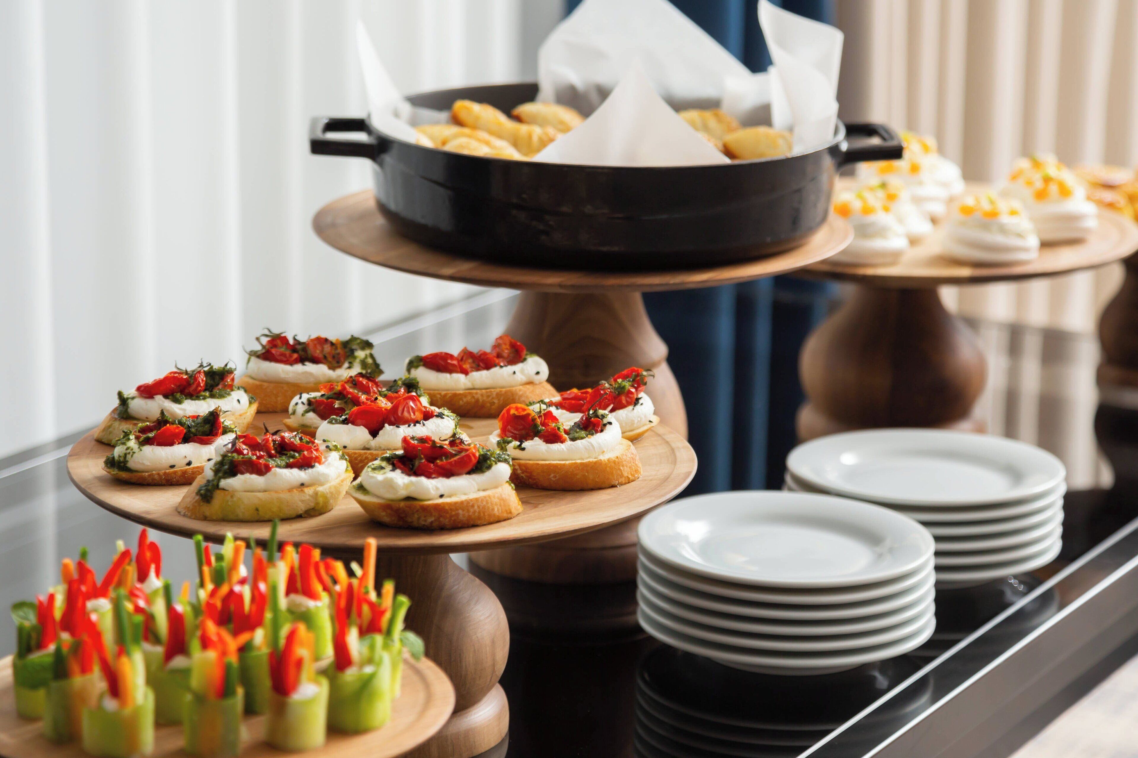 A buffet setup with various appetizers, including stuffed bread and vegetable skewers.