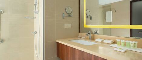 A modern bathroom with a shower, sink, and vanity.