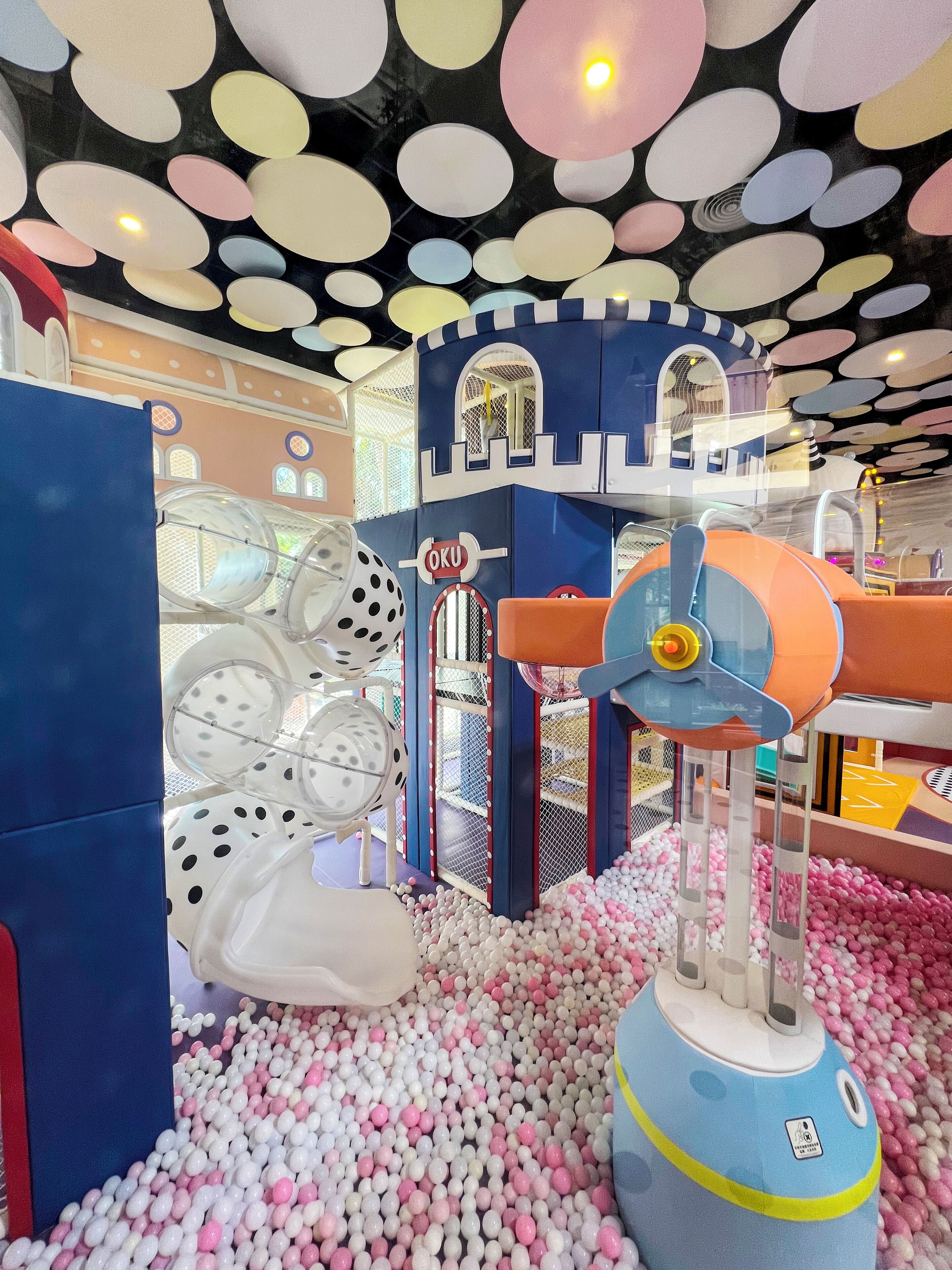 A children's play area with a ball pit, climbing structures, and a castle-themed playhouse.