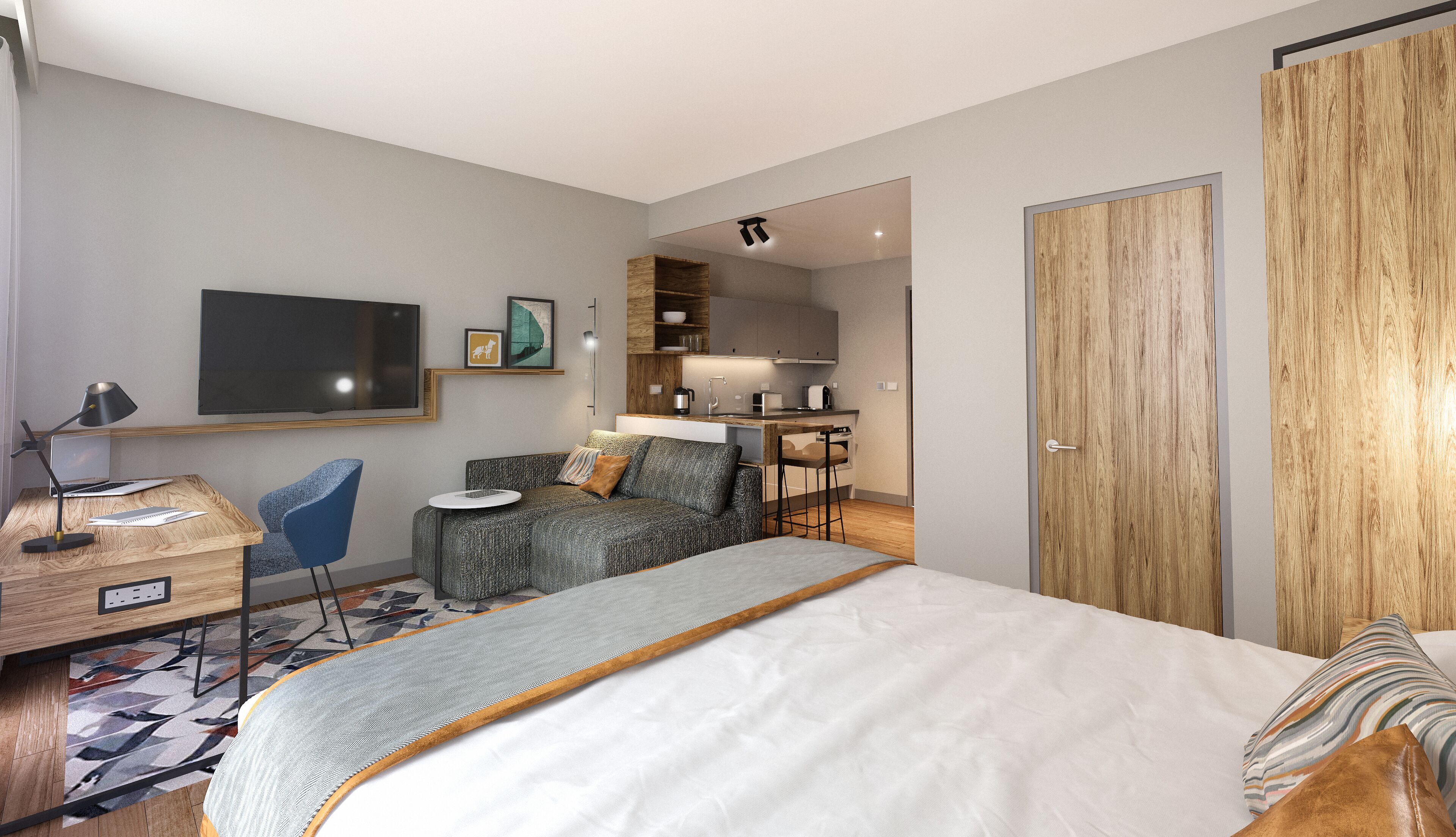 Une chambre moderne avec un grand lit, un bureau, une chaise et, au fond, un coin cuisine.