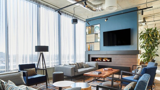 Una sala de estar moderna con chimenea, asientos cómodos y un televisor grande.