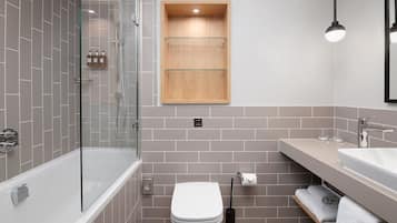 Une salle de bain moderne avec une douche à parois de verre, des toilettes blanches, un meuble à pharmacie en bois et un meuble-lavabo avec un évier et un porte-serviettes.