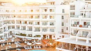 Un hôtel à plusieurs étages doté d’une piscine, d’un espace extérieur aménagé et d’un bar/salon.