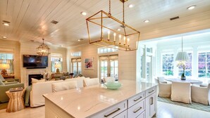 A spacious living room with a large white sofa, a fireplace, and a television. - WaterColor - 4+BR, Private Heated Pool, 6 Seat LSV - 6 Bikes (Santa Rosa Beach)