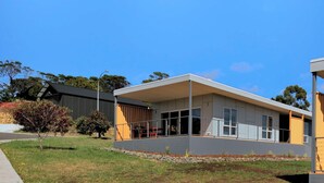 A modern building with a flat roof, large windows, and a covered outdoor area. - Archella 2 - Freycinet Holiday Houses (Coles Bay)