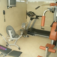Un gimnasio con cinta de correr, banco de pesas y equipamiento de ejercicio.
