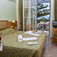 Una habitación de hotel con una cama, una silla, una mesa y un televisor.