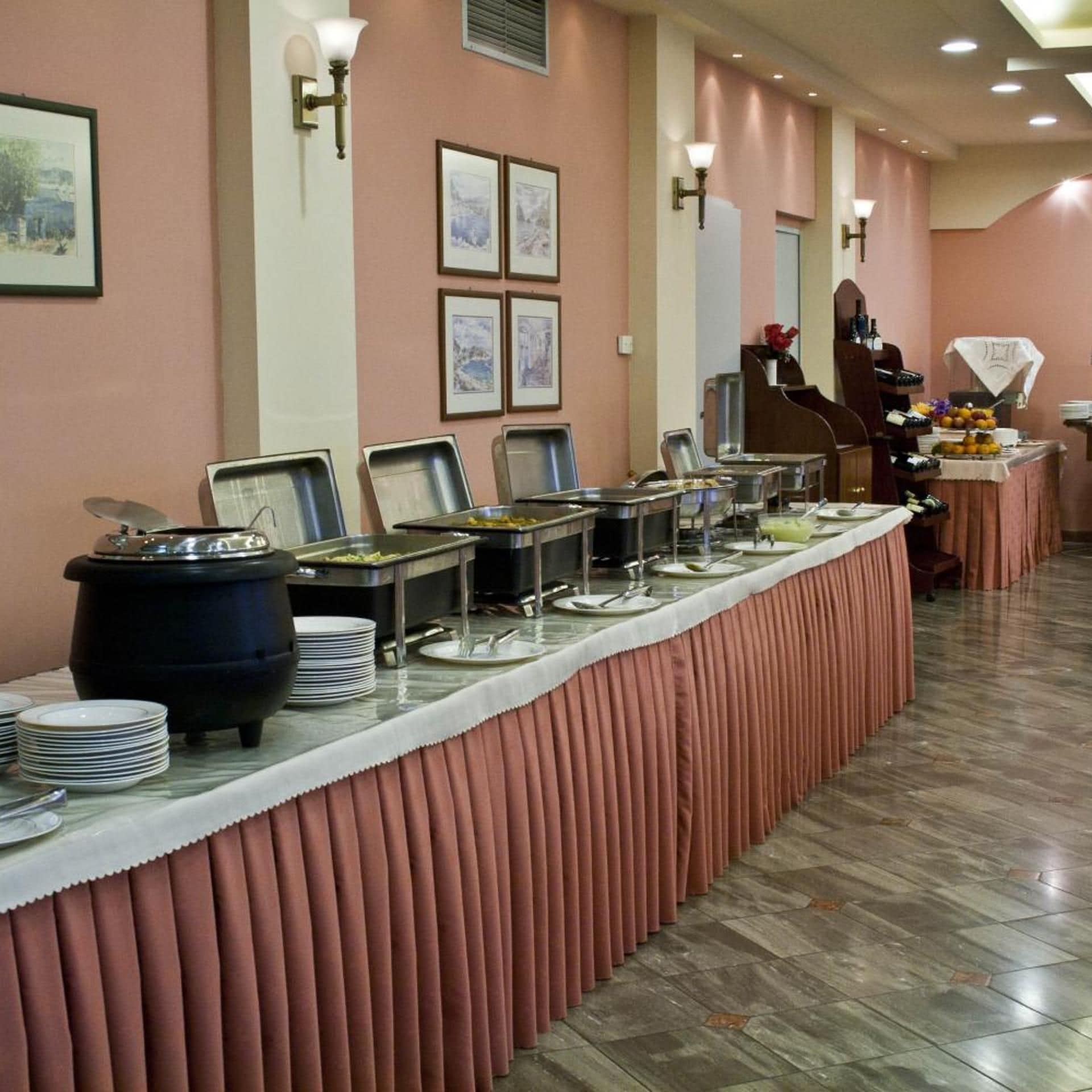 A buffet setup with multiple serving stations, a counter with a variety of dishes, and wall-mounted light fixtures.