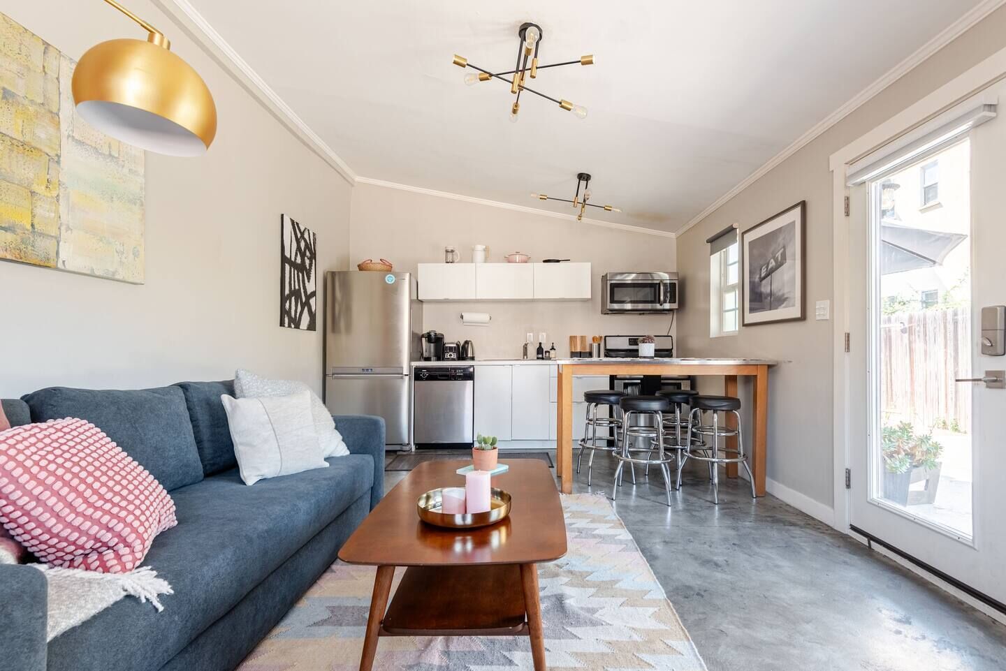 A compact living space with a sofa, coffee table, and a kitchenette area.