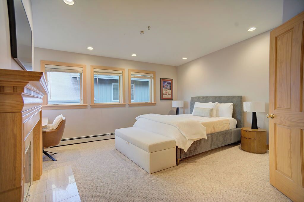 A bedroom with a bed, bedside tables, a chair, and a door.