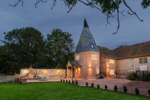 A brick tower with a conical roof, a stone wall, and a small wooden building with a door. - The Hop Kiln and The Hayloft are two unique and attractive holiday lets (Monkland nr Leominster)