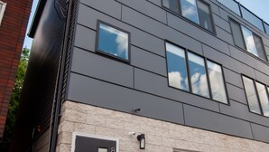 Un bâtiment moderne à deux étages, doté d’un toit plat, de grandes fenêtres et d’une porte de garage.