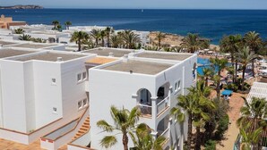 A coastal hotel with white buildings, a pool area, and a beach view. - Sirenis Club Aura (Sant Josep de sa Talaia)