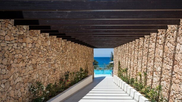 A stone pathway leading to a pool with a clear view of the sea. - Sirenis Club Aura (Sant Josep de sa Talaia)