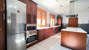 Uma cozinha moderna com eletrodomésticos de aço inoxidável, armários de madeira e uma ilha central.
