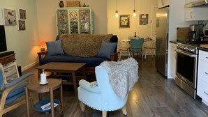 Ein modernes Wohnzimmer mit Sofa, Sessel und Essbereich.