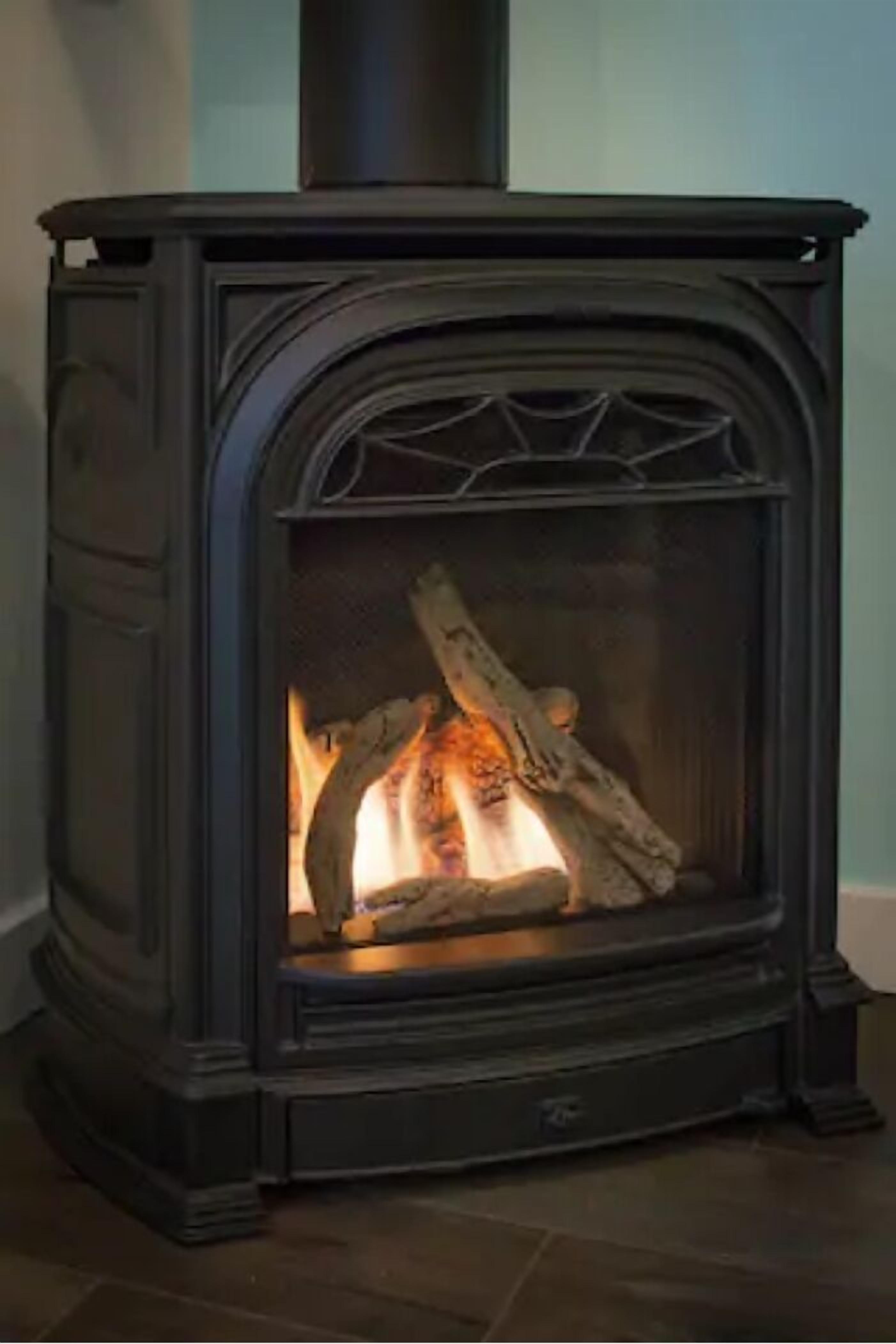 A wood-burning stove with a fire burning inside.