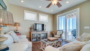 Un salon comprenant un téléviseur, un canapé, une table basse et un ventilateur de plafond.