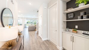 A modern kitchen with white cabinetry, a coffee bar, and a sign indicating a WiFi password.