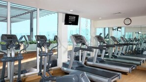 A gym with multiple treadmills and elliptical machines, large windows, and a sign reading "FOUR POINTS BY SHERATON". - Four Points by Sheraton Veracruz (Boca del Río)