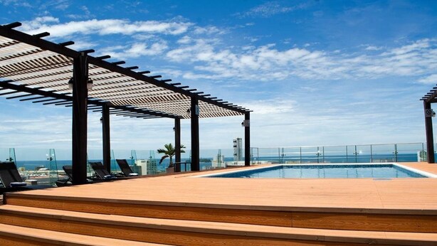 A rooftop pool area with a pergola, lounge chairs, and a view of the ocean. - Four Points by Sheraton Veracruz (Boca del Río)