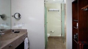 Une salle de bain avec un lavabo, un miroir et des toilettes.