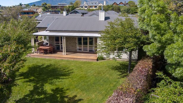 A house with a patio, a covered outdoor seating area, and a view of the surrounding neighborhood and mountains.
