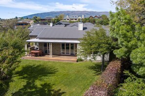 A house with a patio, a covered outdoor seating area, and a view of the surrounding neighborhood and mountains.