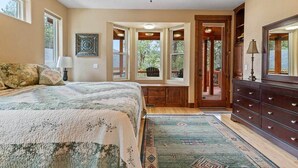 Un dormitorio con cama, cómoda, ventilador de techo y ventana con vistas al exterior.