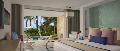 Une chambre d’hôtel avec un lit, un bureau, une chaise, une petite table et une vue sur une piscine et des palmiers.