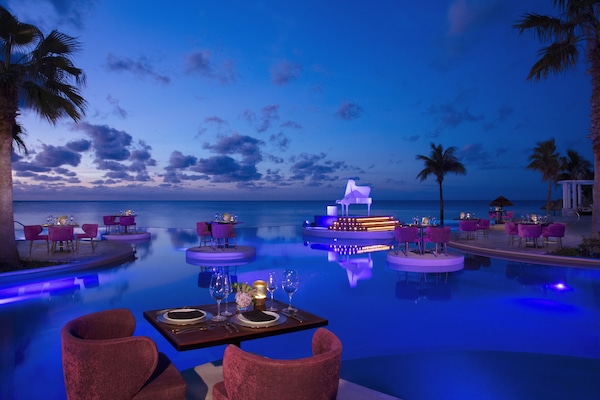 Una piscina al aire libre, sombrillas, tumbonas