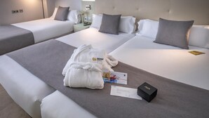 A hotel room with two beds, a nightstand, a lamp, and a robe on the bed. - Hotel Serhs Del Port (Barcelona)