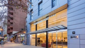 A hotel with a modern facade, large glass windows, and a visible reception area. - Hotel Serhs Del Port (Barcelona)