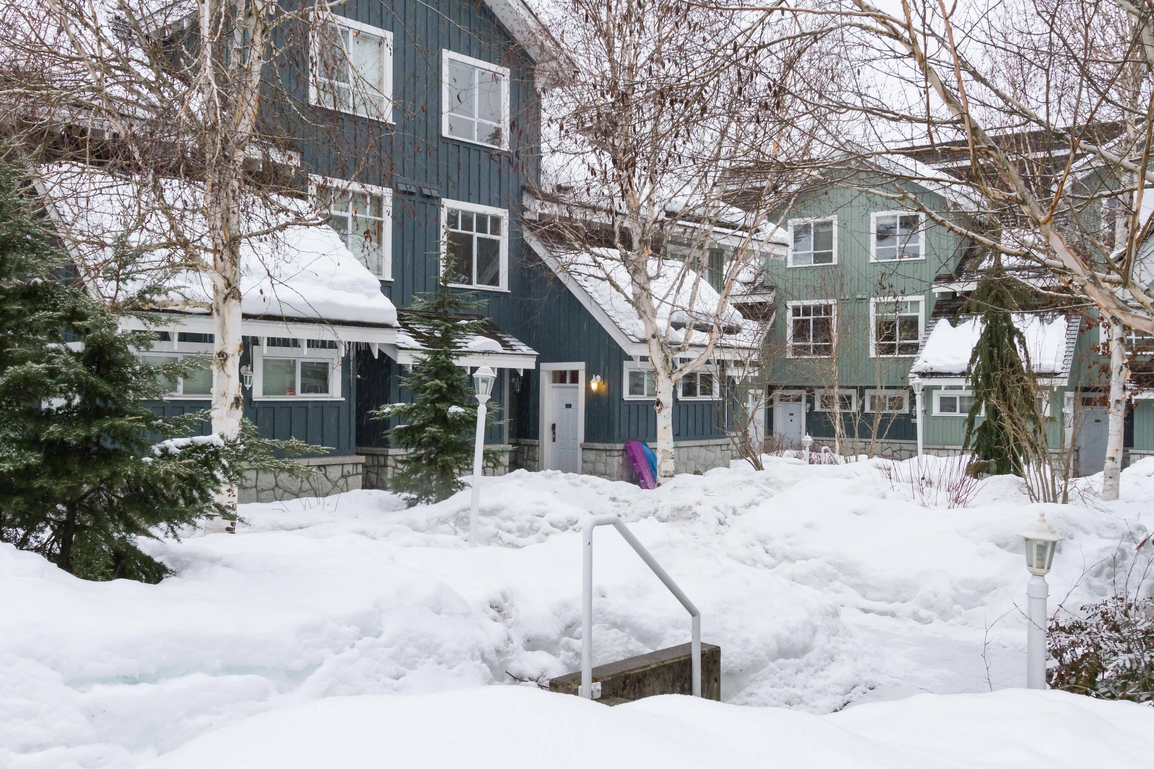 A residential area with snow-covered ground and houses.