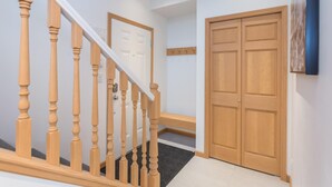 A staircase with wooden balusters leading to a landing with a door and a wall-mounted artwork. - Bright and Clean, Walk Everywhere, Shared Pool and Hot Tub (Whistler)
