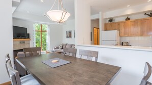 A modern kitchen with wooden cabinets, a built-in oven, and a refrigerator. - Bright and Clean, Walk Everywhere, Shared Pool and Hot Tub (Whistler)