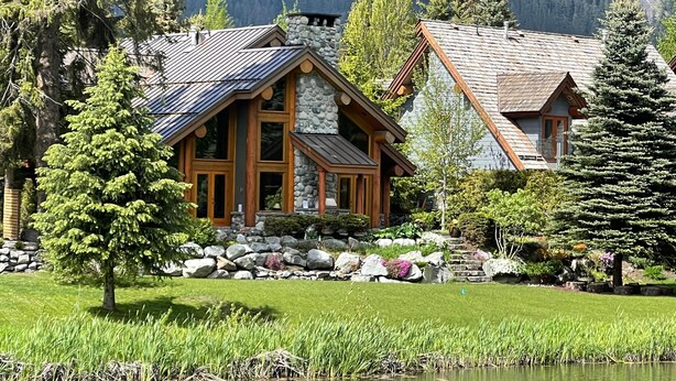 Un chalet doté d’une façade en pierre, de boiseries et d’une grande fenêtre.