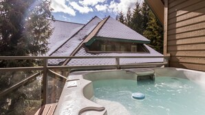 A hot tub area with a view of a building with a sloped roof and a wooden deck. - Fabulous Location Private Hot Tub, NO Car Needed, Sleeps 8 (Whistler)