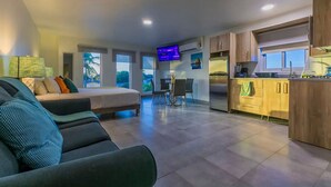 Une chambre d’hôtel moderne comprenant un lit, un canapé, un coin repas et une cuisine.