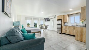 Un appartement moderne comprenant un espace de vie, une cuisine et un coin repas.