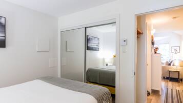 A bedroom with a bed, a wardrobe, and a mirror.