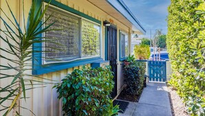 A house with a blue door, large windows, and a small garden area.