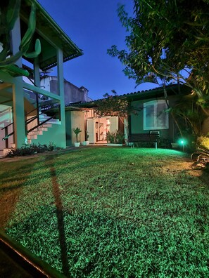 A modern house with a well-maintained lawn, a staircase, and a porch area. - Pousada Casa Centro Búzios (Búzios)