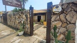 Una entrada de pared de piedra a una propiedad llamada Casa Centro, con un letrero que indica un número de contacto.