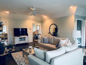 Relax in this stylish living room with a flat-screen TV, comfortable sofa, and decorative coffee table.