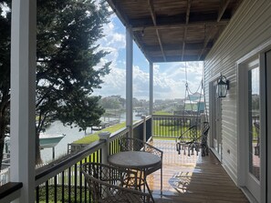 Relax on the waterfront deck with a view of the dock and surrounding grassy area.